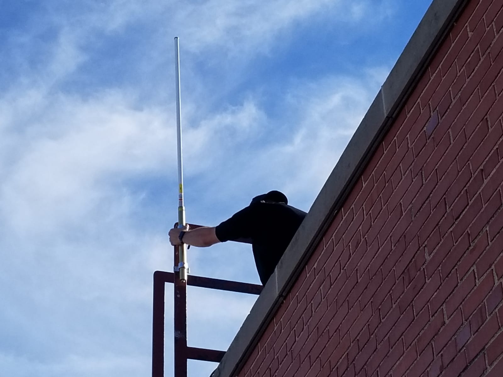 A person making adjustments to communications equipment