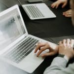 Someone using a laptop in a meeting