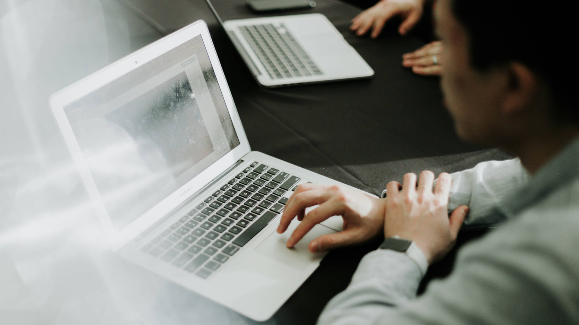 Someone using a laptop in a meeting