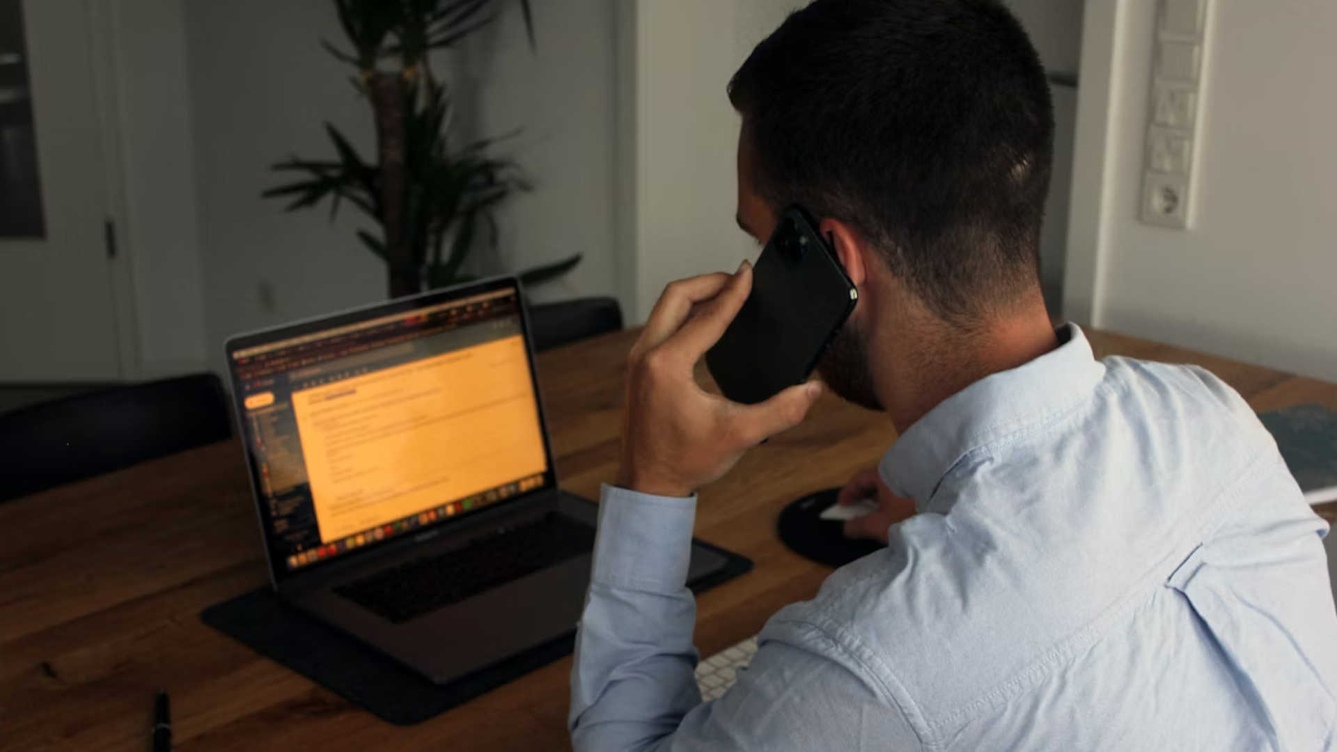 A person on a phone call as well as using their laptop