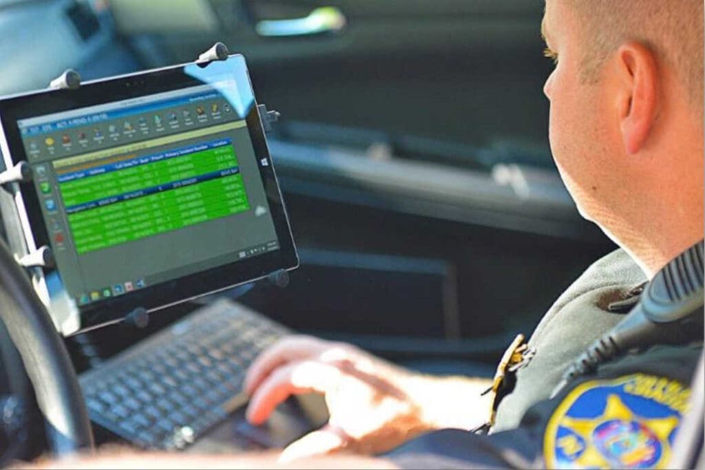 A police officer using a laptop in their car